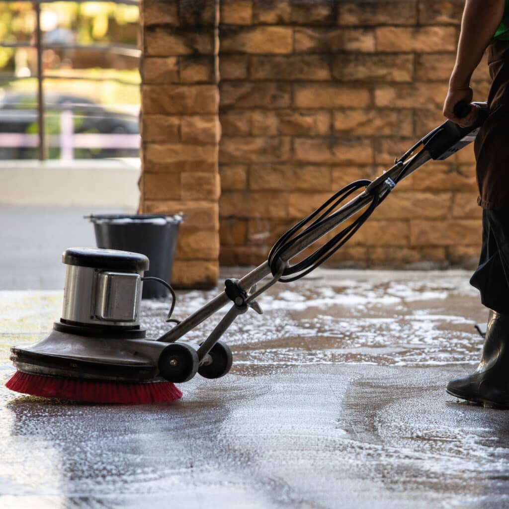 A man worker cleaning the floor with polishing machine